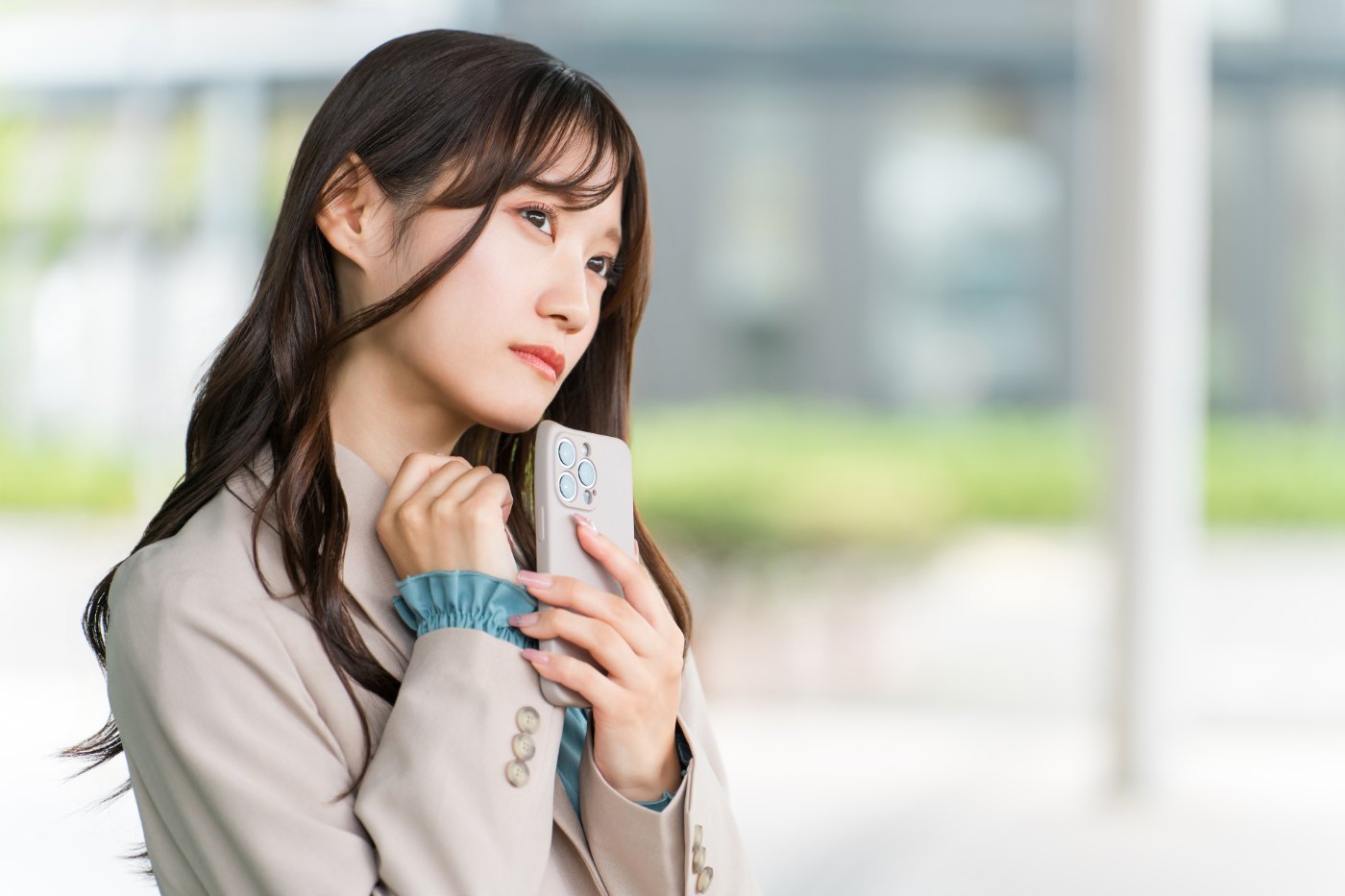 スマートフォンを手に悩む20代女性